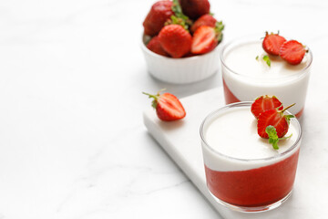 Strawberry creamy dessert - panna cotta with strawberry in a glass jars decorated with fresh...