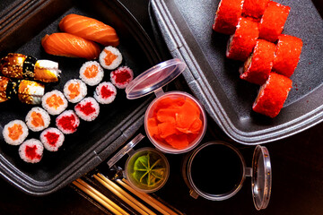 Set of delicious sushi rolls with wassabi and ginger in a box. Japanese food.
