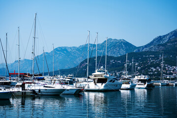 Luxury yachts port in Montenegro with mountains and city view. Boats pier in Adriatic sea with beautiful Mediterranean nature