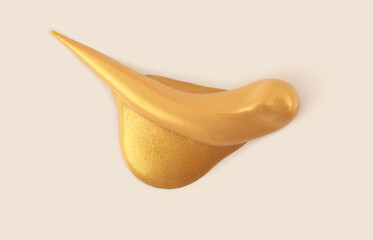 Art gold Acrylic smear blot drop on beige background. Abstract texture color painting stain.