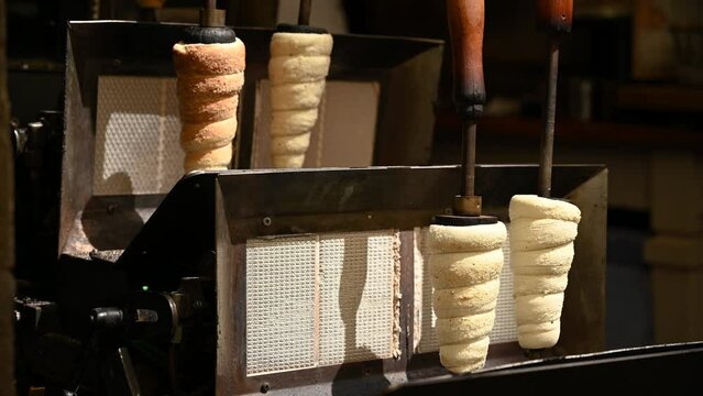 National Czech trdelnik sweet delicacy that is prepared on the street in 4K. Fresh baked Trdelnik with sugar and nuts in basket close-up. Traditional czech cuisine. Cooked national bohemian food.