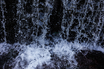 Fototapeta na wymiar Waterfall with flowing water closeup