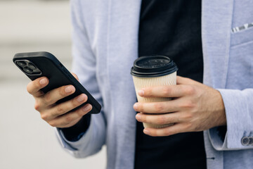 Appealing elegant man using social media application on smartphone text messages receive news outdoor. Technology