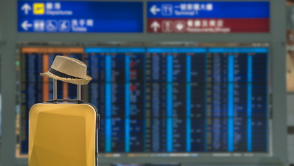 Suitcase with hat on flight timetable background. - 517402139