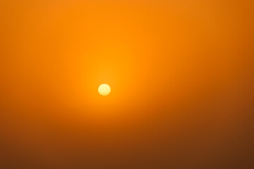 rising sun on clear golden gradient sky with visible spots in the sun, without horizon,...
