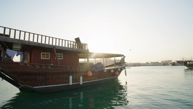 Doha skyline afternoon shot showing Dhows with Qatar flags in the Arabic gulf in foreground and Doha skyline in background
