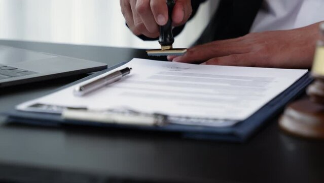 Close up of hands are signing and stamp on agreement paperworks.