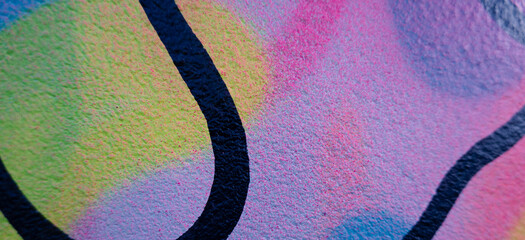 Fragment of the wall with colorful graffiti painting in the street. Part of colorful street art...