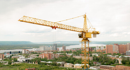 Fototapeta na wymiar tower crane top view. building background river, sunset, mountains. concept construction, new buildings, architecture and industry. construction big city against backdrop city mountains