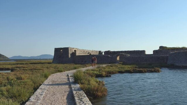 Ksamil, Albania A couple walks up to the Ali Pasha Castle holding hands. 
