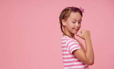 Portrait of surprised cute toddler girl child in star-shaped sunglasses over pink background. Points hands to the left side. Advertising childrens products