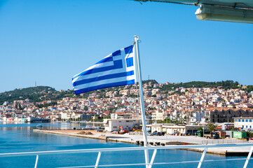 Drapeau grec flottant à la poupe d'un navire ,en arrière plan Argostoli en Céphalonie