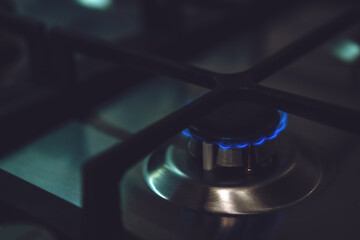 Closeup of blue gas flame on domestic kitchen stove. Gas cooker with burning flames