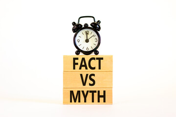 Fact vs myth symbol. Concept words Fact vs myth on wooden blocks on a beautiful white table white background. Black alarm clock. Business, finacial and fact vs myth concept. Copy space.