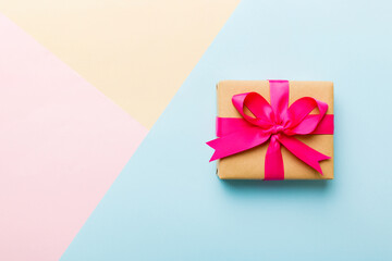 holiday paper present tied pink ribbon bow top view with copy space. Flat lay holiday background. Birthday or christmas present. Christmas gift box concept with copy space