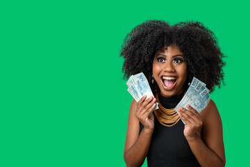 woman holding money, young smiling woman holding Brazilian money, green background