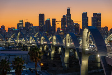 New 6th Street bridge in Los Angeles at sunset with the Los Angles skyline in the distance - obrazy, fototapety, plakaty