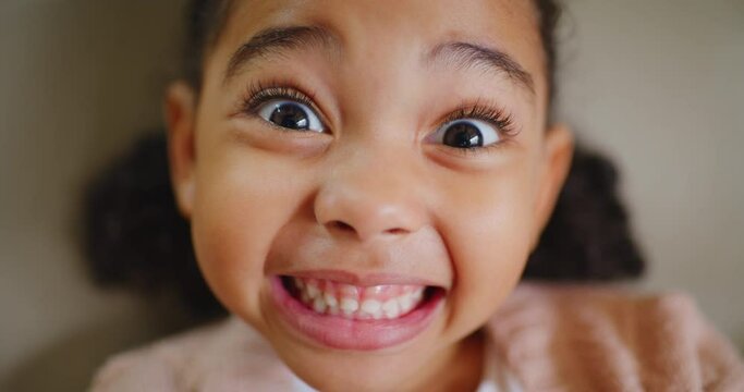 Closeup of a girl showing her teeth at a dentist check up. Orthodontist POV of playful little child smiling and feeling confident after her oral hygiene appointment at a dental healthcare clinic
