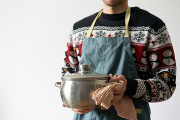 chef in apron cooking dish holding a pot in the kitchen