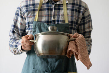 chef in apron cooking dish holding a pot in the kitchen