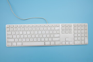 white keyboard blue background viewed from above