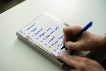 writing a shopping list on the paper, buying reminder