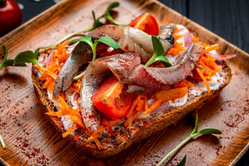 Sandwich with slices of pickled Atlantic herring fillet, pickled onions and carrots