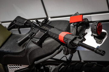 Fototapeta premium Automatic carabiner on a motorcycle. Weapons for police, special forces and the army. Automatic carbine with mechanical sights.