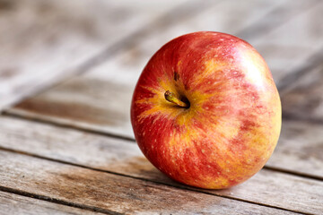 A delicious, ripe red fruit on a table picked during summer harvesting season for a vegetarian, vegan friendly or healthy lifestyle. Closeup of one fresh harvested apple with copy space