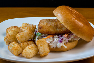 fish sandwich  on cole slaw between  a brioche bun