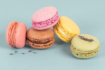 Cake macaron or macaroon on turquoise background from above, colorful almond cookies, pastel colors, vintage card