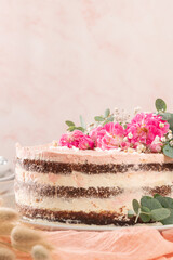 Obraz na płótnie Canvas Chocolate naked cake with fresh roses and swiss buttercream on a white background