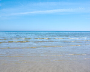 Sea and ocean view of waves washing onto an empty and relaxing tropical beach on a warm, summer day. Seascape with clear blue sky and copy space of calm water on a remote and secluded island