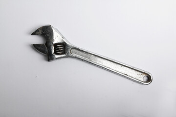 Adjustable wrench, made of wrought iron with chrome coating, isolated white background.