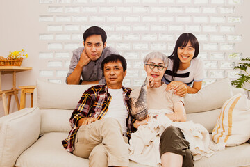 Portrait of four people in a warm family : Happy Asian families take pictures together to commemorate memories and gifts in a home with lovely parents, brother and sister.