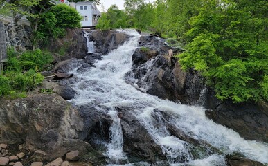 rocks and waterfall or cascade with trees and buildings