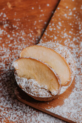 Cupcake casero con rodajas de manzana, rodeado de azúcar encima de mesa de madera, deliciosos dulces de pastelería, desayuno rústico de manzana