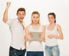 Obraz premium team of young business people in white shirts on a white background isolated. a team of two girls and a guy is happy, wins, plans, argues, discusses, gets upset, wins something. close-up portrait 