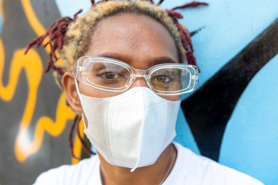 Close up image of a black woman with her blank white face mask