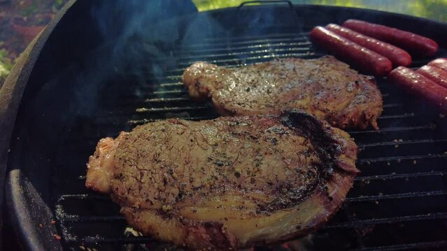 Cooking ribeye steaks on hot BBQ grill