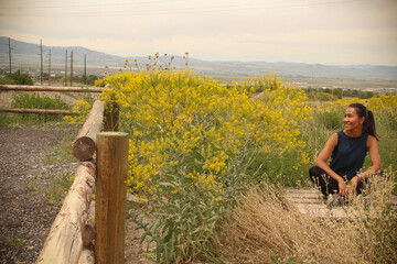 Woman enjoying field mustard wildflowers, King Nature Park, North Logan, Utah