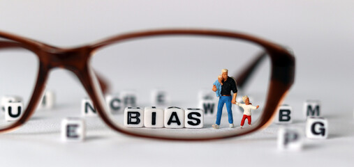 Glasses and a miniature man with children. Business concept with white cube arranged in the word ...