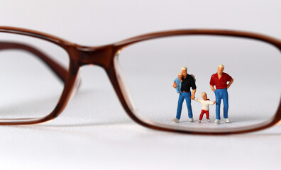 Business concept with glasses and miniature family. Concept about 'love is love'. 
