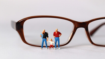 Business concept with glasses and miniature family. Concept about 'love is love'. 
