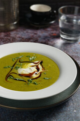 Potato soup with pureed lamb's lettuce, served in white plate