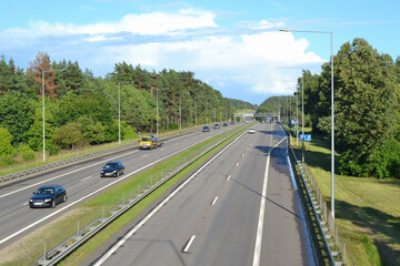 Traffic on the intercity highway between the natural parkland. Top view.