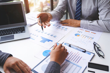 Two confident executive business colleagues meeting and discussing ideas of the project about company offers, they are pointing at a document and giving explanations, team successful business people.