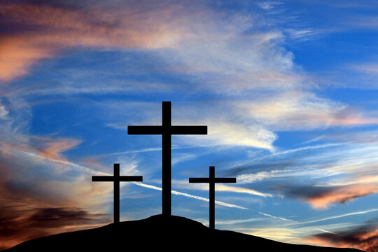The three crosses of the crucifixion of Jesus Christ  are seen in silhouettes in front of a colorful sky in this 3-d illustration.