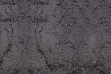 Dark gray background from natural slate. Texture of stone closeup. Graphite background macro
