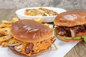 Burger with melting cheese in front of BBQ burger and chili cheese dogs for a tough choice in comfort food to eat
